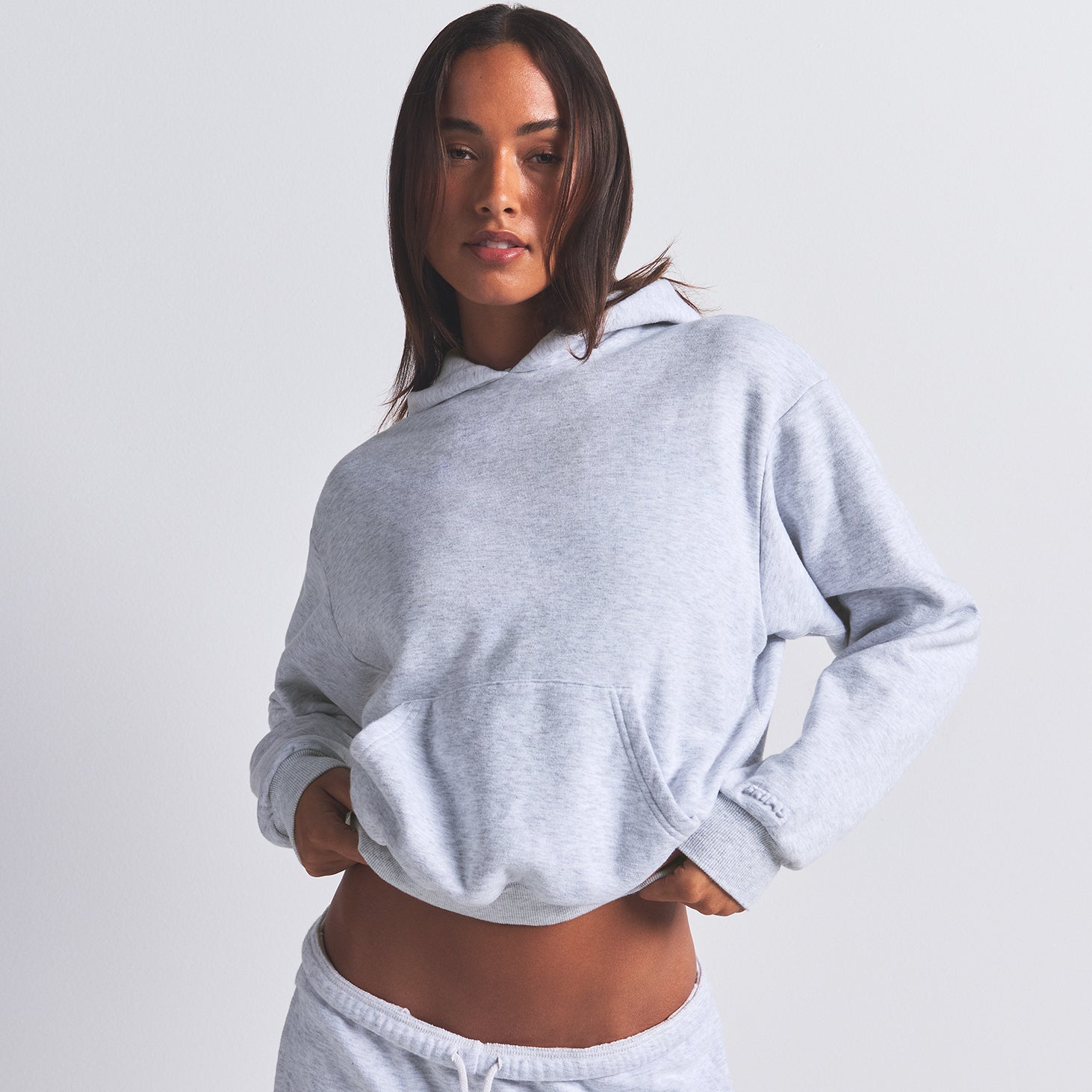 COTTON FLEECE CLASSIC HOODIE | LIGHT HEATHER GREY ON A MODEL FRONT VIEW | FOCUS: 0.0, 1.0, 0.9