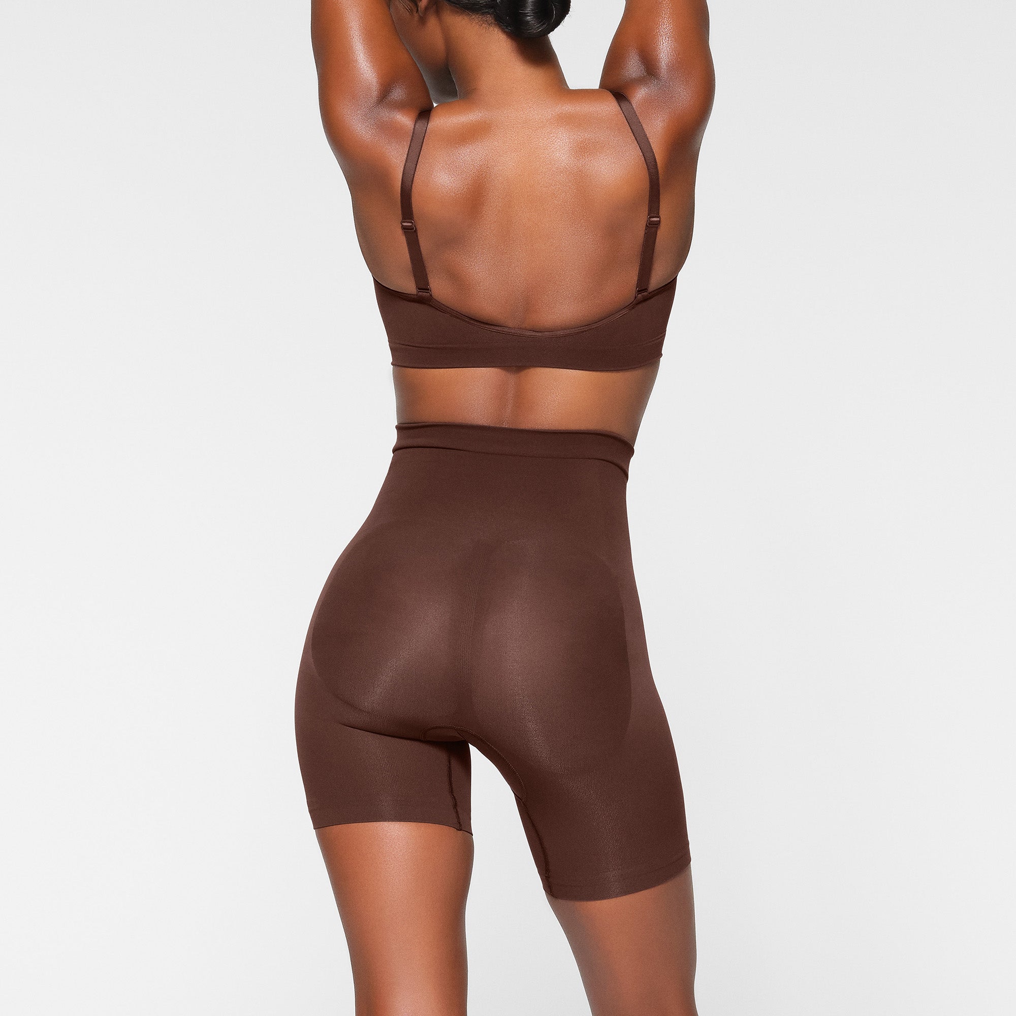 SEAMLESS SCULPT MID THIGH SHORT ON A MODEL BACK VIEW