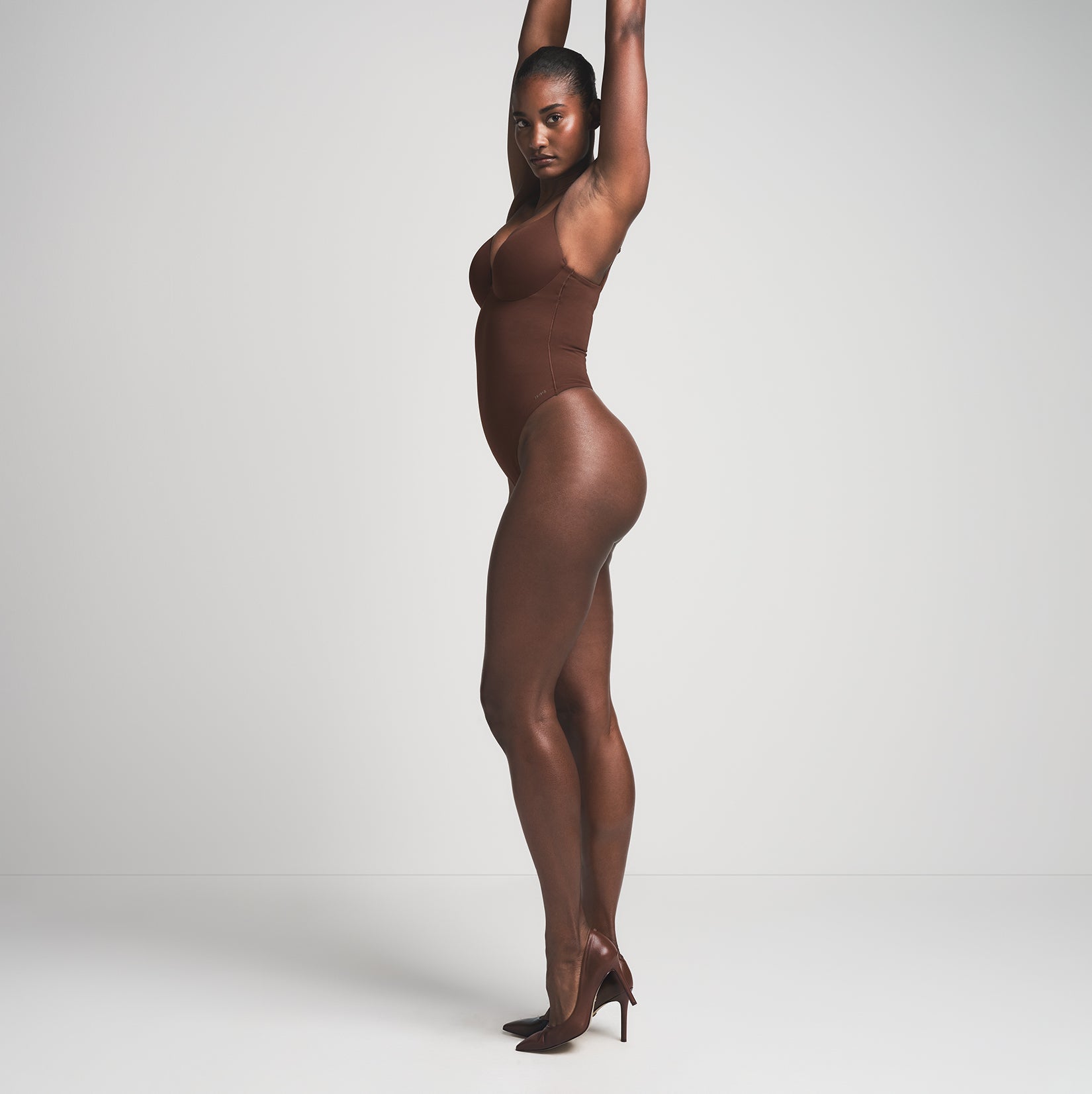 SKIMS ULTIMATE BODY PUSH-UP THONG BODYSUIT | COCOA ON A MODEL SIDE VIEW | FOCUS: 0.0, 1.0, 0.9