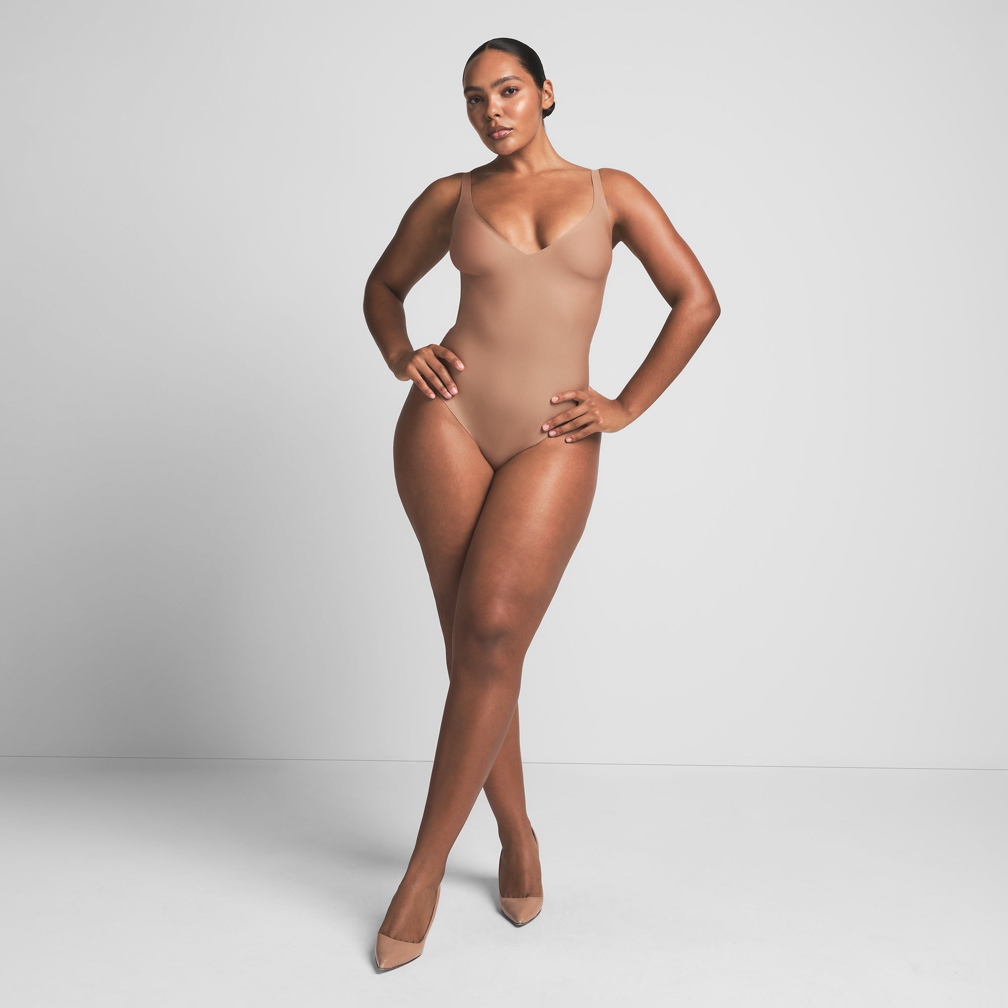 SKIMS BODY UNLINED PLUNGE THONG BODYSUIT | SIENNA ON A MODEL FRONT VIEW | FOCUS: 0.0, 1.0, 0.9