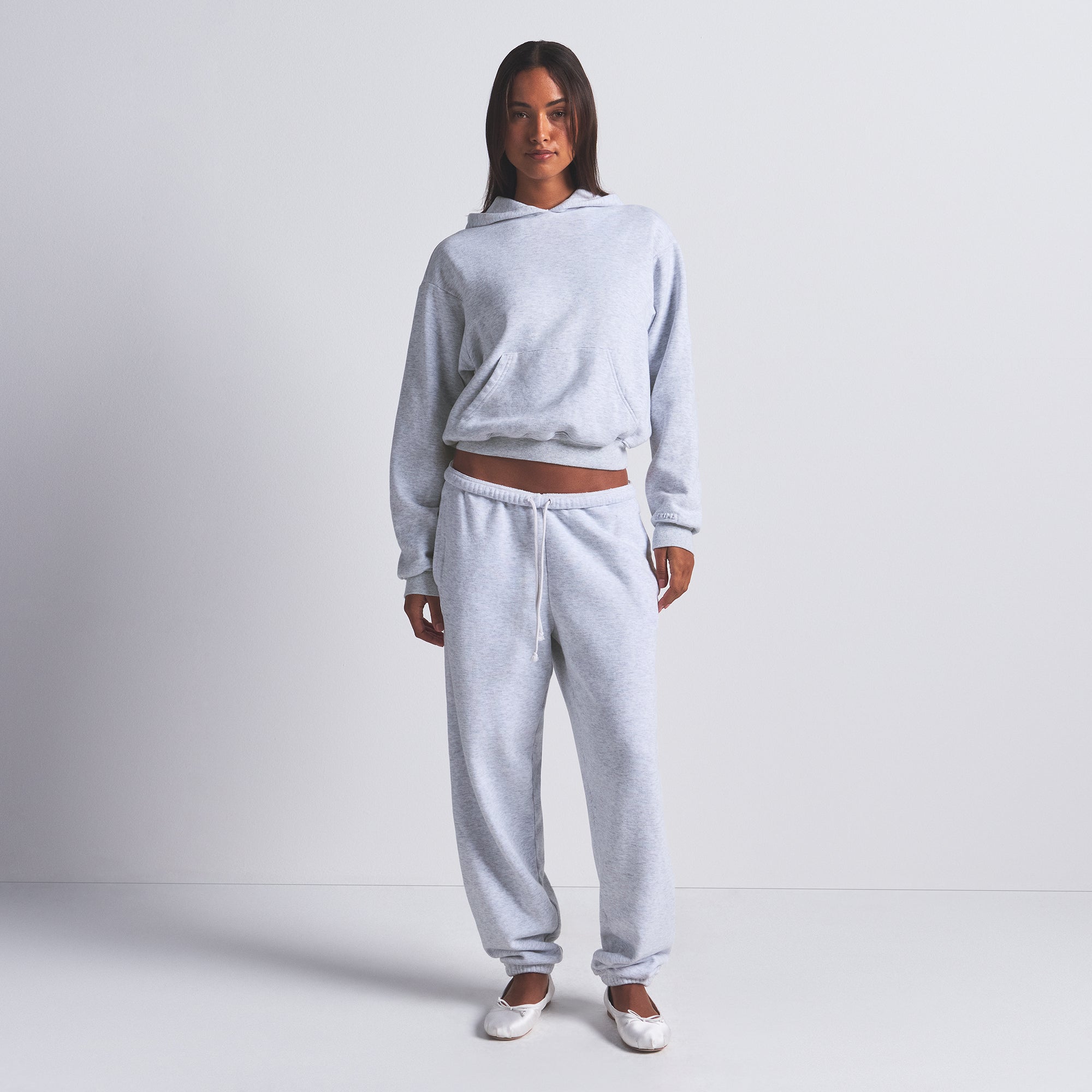 COTTON FLEECE CLASSIC HOODIE | LIGHT HEATHER GREY ON A MODEL FRONT VIEW | FOCUS: 0.0, 1.0, 0.9