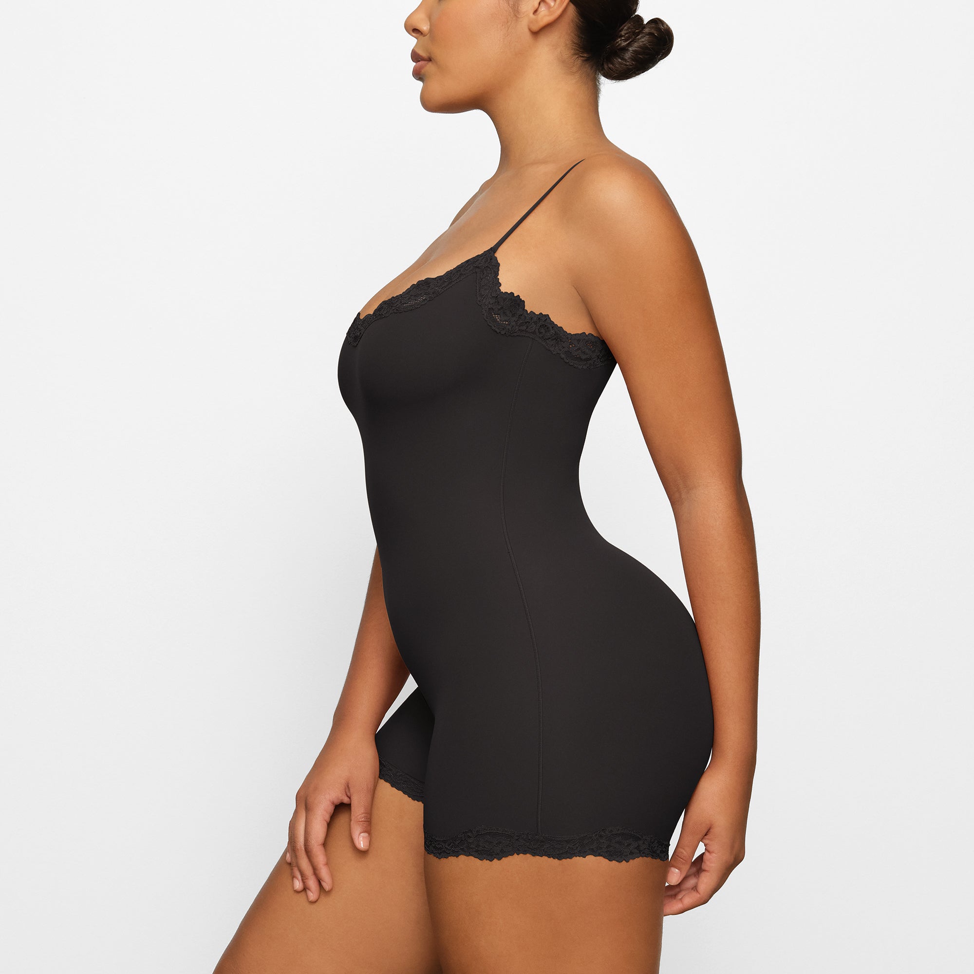 FITS EVERYBODY LACE ONESIE WORN BY A MODEL IN SIDE VIEW